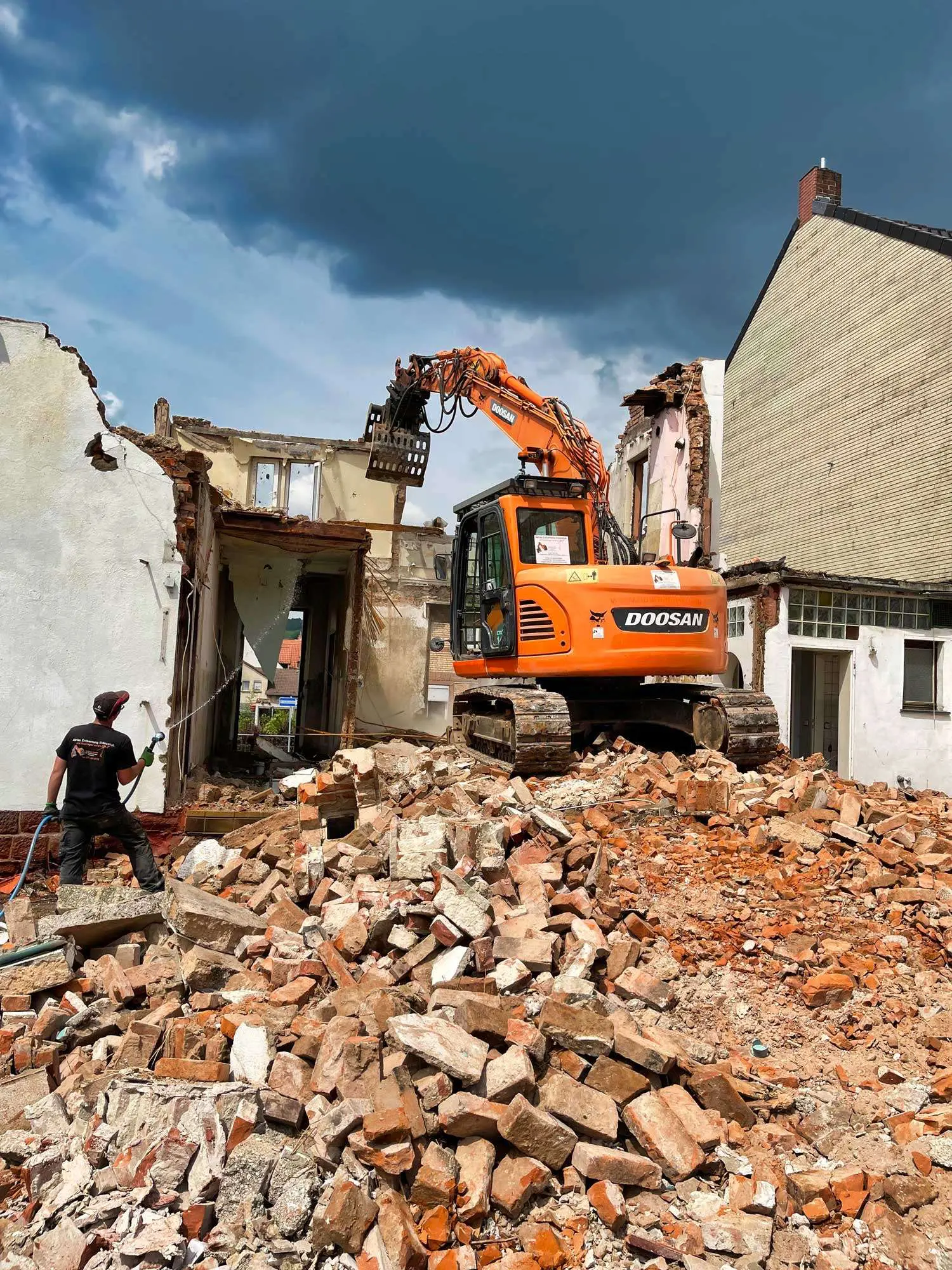 Abbruch: Abrissarbeiten der Firma Wadlinger mit zwei Mitarbeitern und einem großen Bagger in Landau